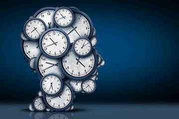 Silhouette of a head crammed with clocks set at different times